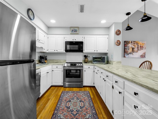 kitchen with visible vents, light stone counters, white cabinets, stainless steel appliances, and light wood-style flooring