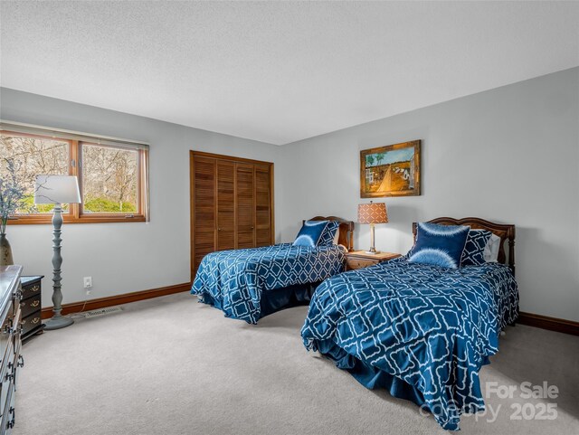 bedroom with a closet, carpet flooring, baseboards, and visible vents