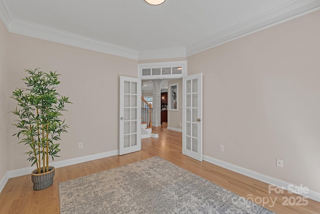 unfurnished room with french doors, ornamental molding, and wood finished floors