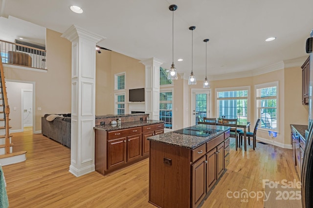 kitchen featuring ornate columns, light wood-style flooring, and black electric cooktop