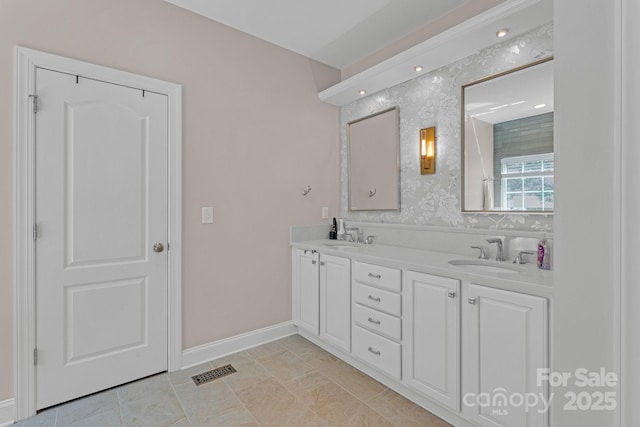 full bath with visible vents, a sink, baseboards, and double vanity