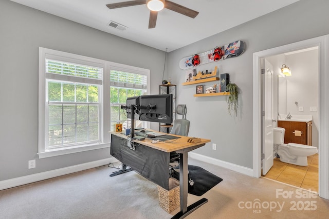 carpeted home office with visible vents, a ceiling fan, baseboards, and plenty of natural light