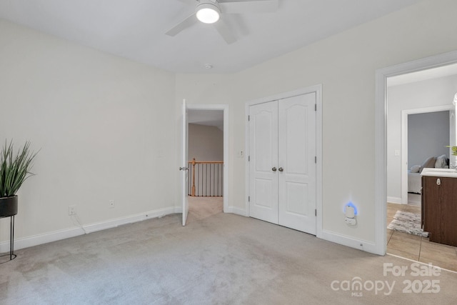 unfurnished bedroom featuring a ceiling fan, baseboards, carpet, and a closet