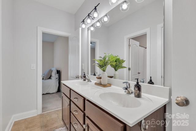 full bathroom featuring double vanity, baseboards, a sink, and tile patterned flooring