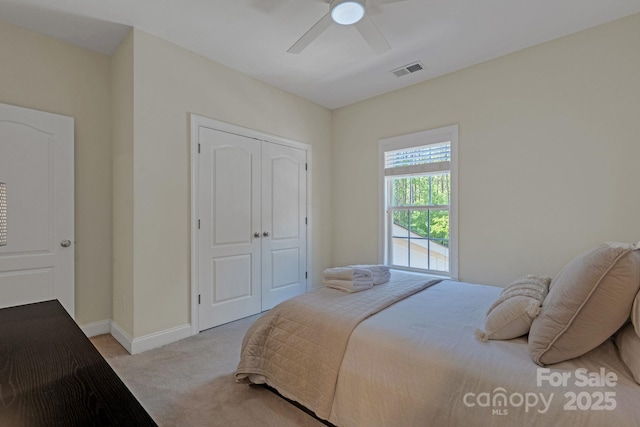 bedroom with ceiling fan, visible vents, carpet floors, baseboards, and a closet