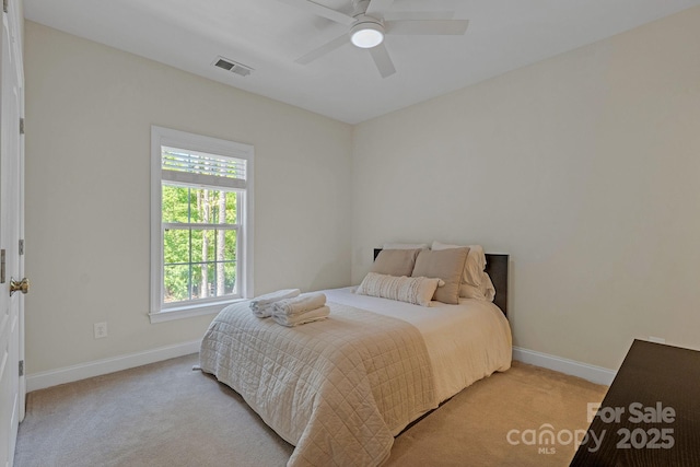 carpeted bedroom featuring visible vents, baseboards, ceiling fan, and multiple windows