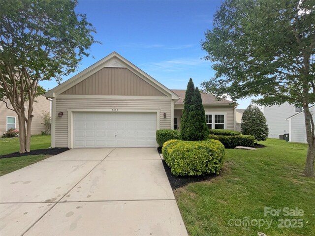 single story home with an attached garage, a front lawn, and concrete driveway