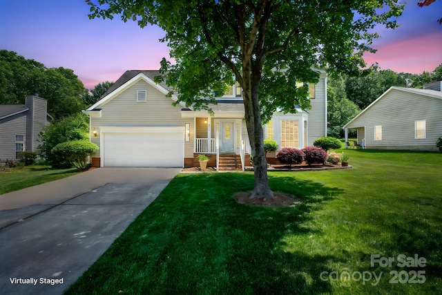 view of front of home with a lawn, driveway, and a garage