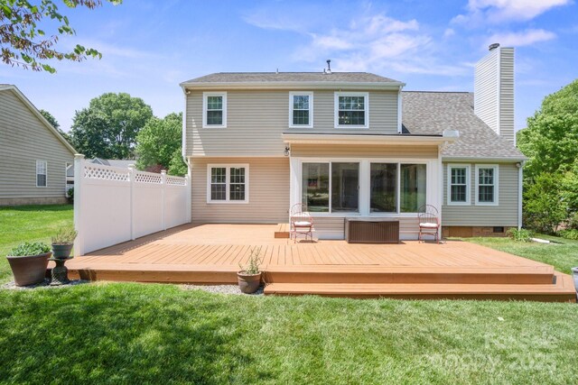 rear view of property featuring fence, roof with shingles, crawl space, a chimney, and a lawn