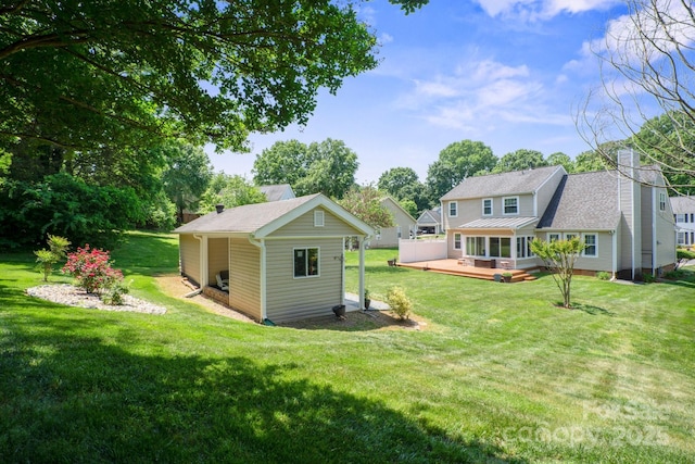 back of house with an outdoor structure, a wooden deck, a chimney, and a yard
