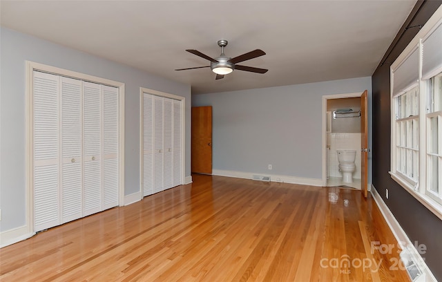 385 Gum Branch Rd, Charlotte, NC 28214 - unfurnished bedroom with multiple closets, baseboards, ensuite bathroom, light wood-type flooring, and visible vents