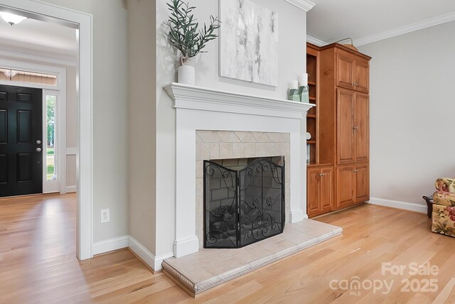 unfurnished living room featuring crown molding, baseboards, and light wood-style flooring