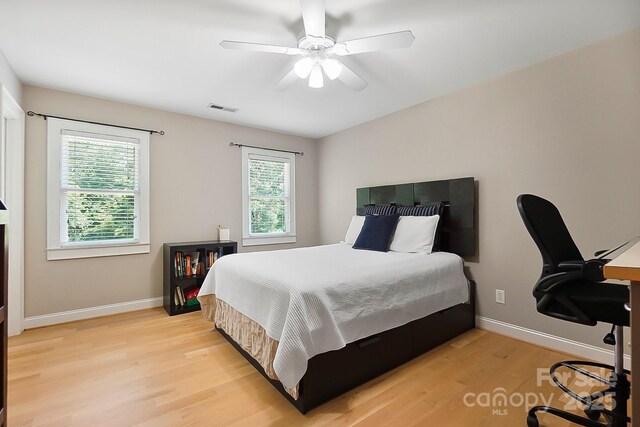 bedroom with visible vents, light wood-style flooring, baseboards, and multiple windows
