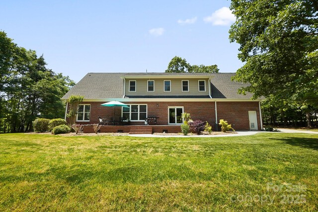 back of house with a yard and brick siding