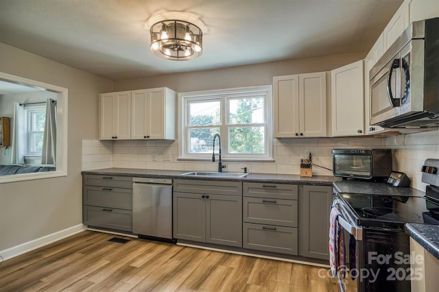 111 Baxter St, Morganton, NC 28655 - kitchen with dark countertops, light wood-type flooring, a sink, gray cabinetry, and stainless steel appliances