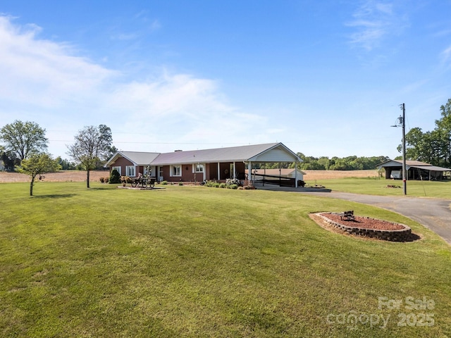 view of front facade featuring an attached carport, driveway, and a front yard