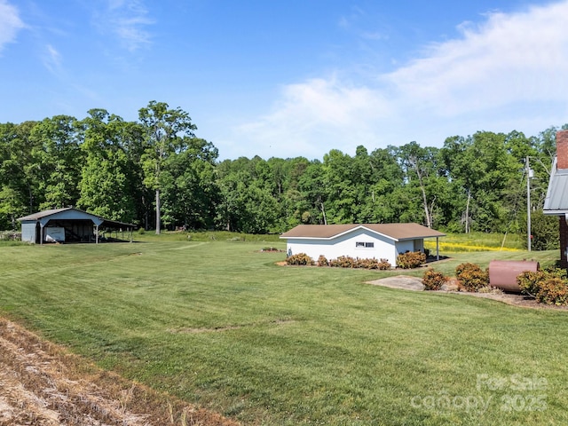 view of yard featuring a detached carport and a forest view