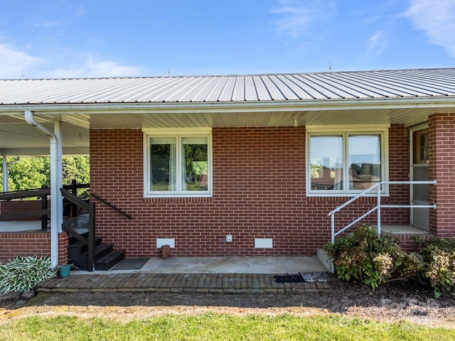 view of front of home with brick siding and metal roof