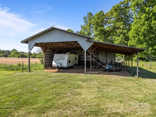 view of parking / parking lot with an outbuilding and a carport