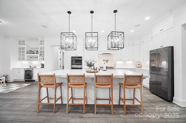 1005 Grand Oak Dr, Waxhaw, NC 28173 - kitchen featuring appliances with stainless steel finishes, beverage cooler, wood finished floors, white cabinetry, and recessed lighting