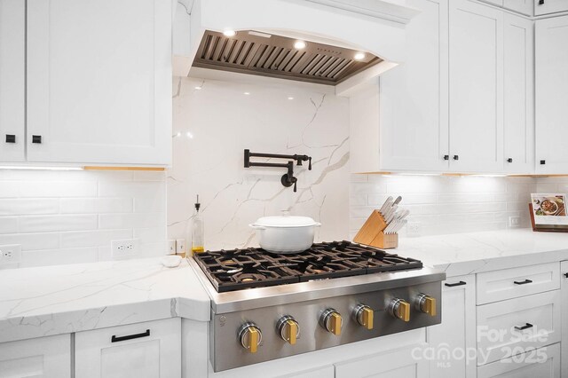 1005 Grand Oak Dr, Waxhaw, NC 28173 - kitchen featuring custom range hood, stainless steel gas stovetop, decorative backsplash, white cabinetry, and light stone countertops