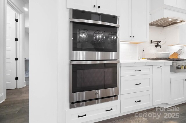 1005 Grand Oak Dr, Waxhaw, NC 28173 - kitchen with appliances with stainless steel finishes, white cabinetry, decorative backsplash, and premium range hood