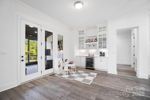 1005 Grand Oak Dr, Waxhaw, NC 28173 - indoor dry bar with beverage cooler, wood finished floors, baseboards, ornamental molding, and french doors