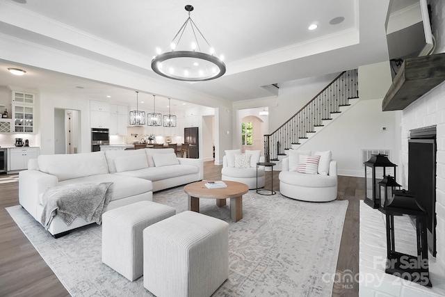 1005 Grand Oak Dr, Waxhaw, NC 28173 - living room featuring a chandelier, wood finished floors, ornamental molding, stairs, and recessed lighting