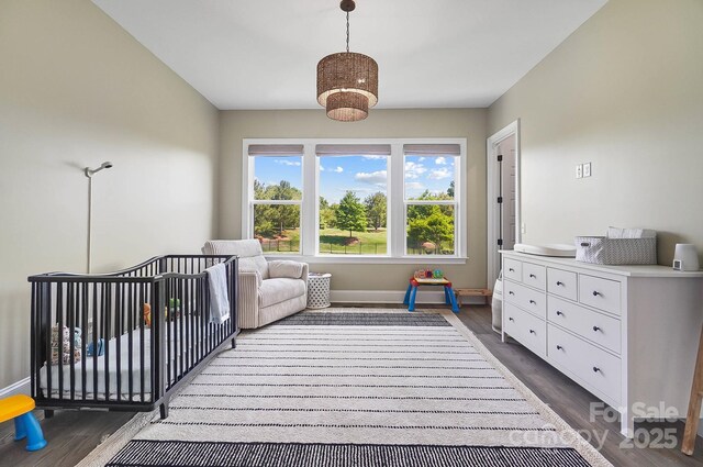 1005 Grand Oak Dr, Waxhaw, NC 28173 - bedroom with dark wood-style flooring, baseboards, and a nursery area