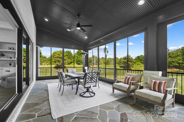 1005 Grand Oak Dr, Waxhaw, NC 28173 - sunroom with view of scattered trees, ceiling fan, stone finish flooring, recessed lighting, and vaulted ceiling
