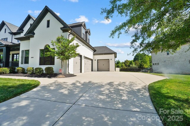 1005 Grand Oak Dr, Waxhaw, NC 28173 - view of home's exterior featuring concrete driveway, a yard, stucco siding, and an attached garage