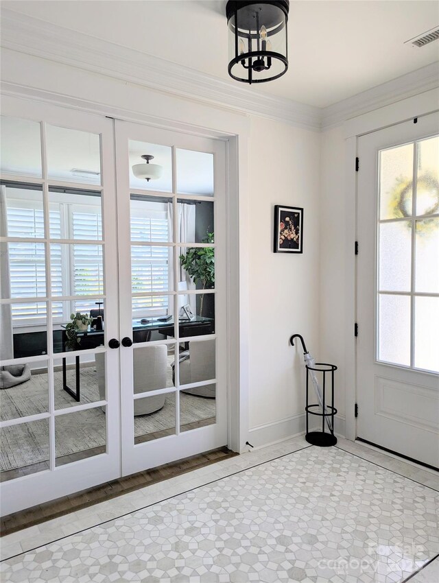 doorway to outside featuring visible vents, crown molding, an inviting chandelier, baseboards, and french doors