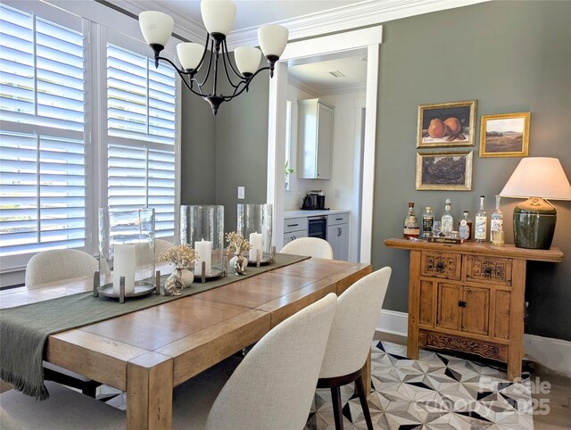 dining area featuring an inviting chandelier, baseboards, and crown molding