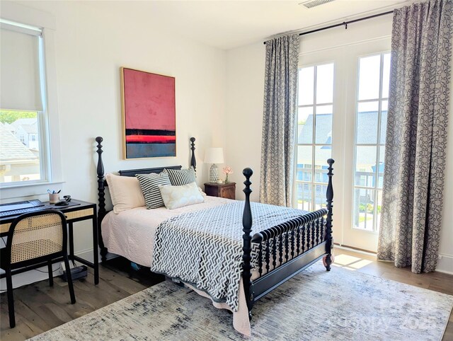 bedroom featuring multiple windows, wood finished floors, and visible vents