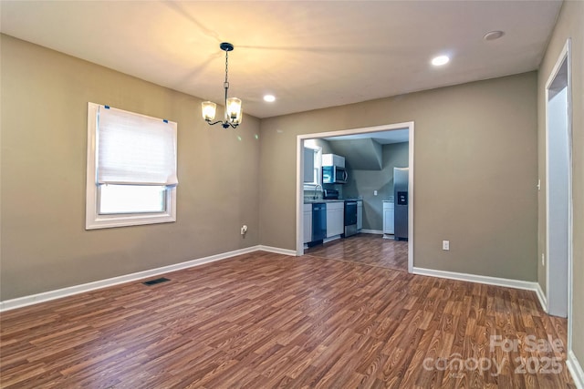 empty room featuring visible vents, baseboards, dark wood-style floors, an inviting chandelier, and recessed lighting