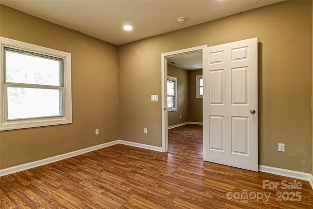 spare room with baseboards, recessed lighting, and wood finished floors