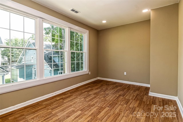 unfurnished room featuring recessed lighting, baseboards, visible vents, and dark wood-style floors