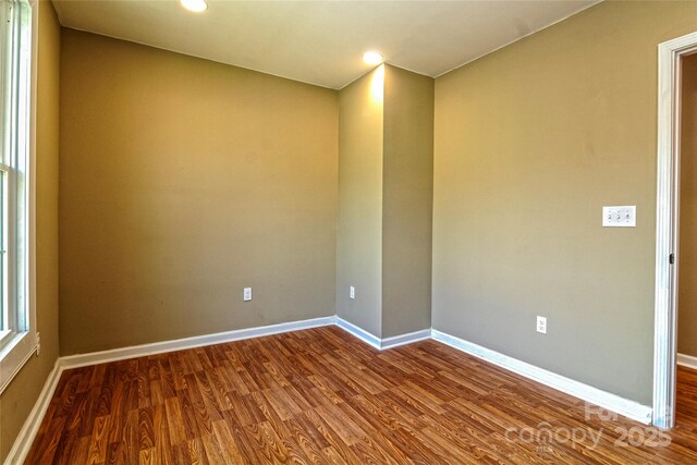 spare room with baseboards, recessed lighting, and dark wood-type flooring