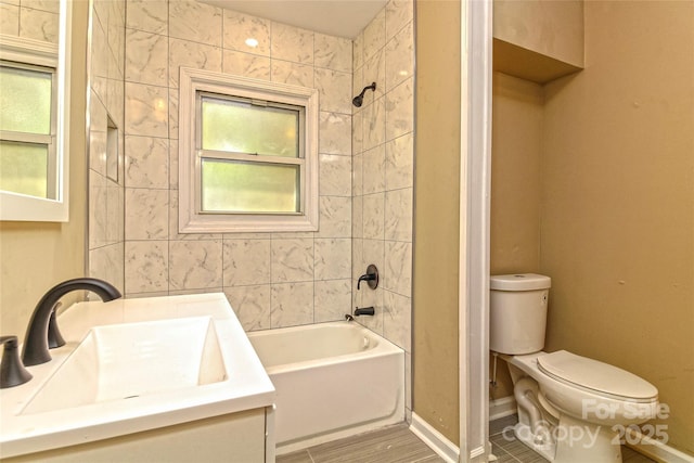 full bathroom featuring baseboards, washtub / shower combination, toilet, and vanity