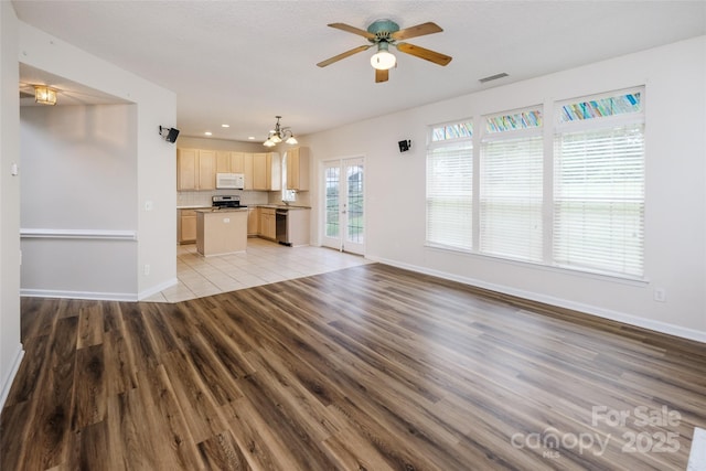16017 Woodcote Dr, Huntersville, NC 28078 - unfurnished living room with light wood finished floors, ceiling fan, a chandelier, baseboards, and recessed lighting
