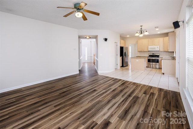 16017 Woodcote Dr, Huntersville, NC 28078 - unfurnished living room featuring light wood-style flooring, ceiling fan, a chandelier, a sink, and recessed lighting