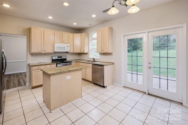 16017 Woodcote Dr, Huntersville, NC 28078 - kitchen with stainless steel appliances, light brown cabinetry, a sink, tasteful backsplash, and a kitchen island