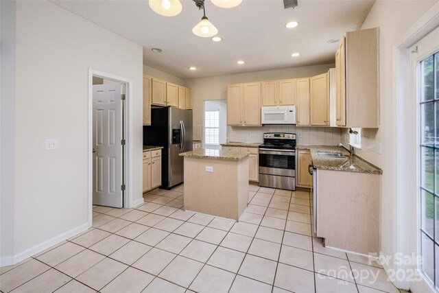 16017 Woodcote Dr, Huntersville, NC 28078 - kitchen featuring appliances with stainless steel finishes, light brown cabinetry, a kitchen island, healthy amount of natural light, and recessed lighting