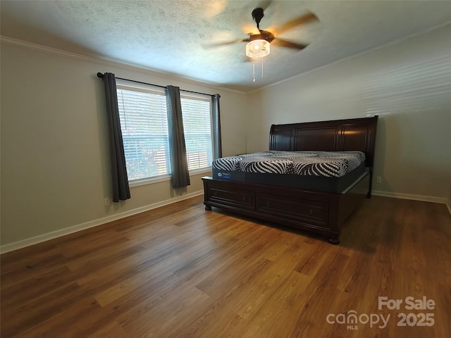 bedroom with ceiling fan, wood finished floors, baseboards, and ornamental molding