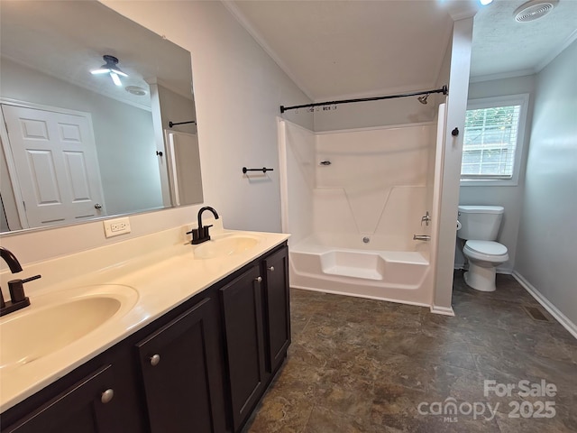 bathroom featuring double vanity, crown molding, toilet, and a sink