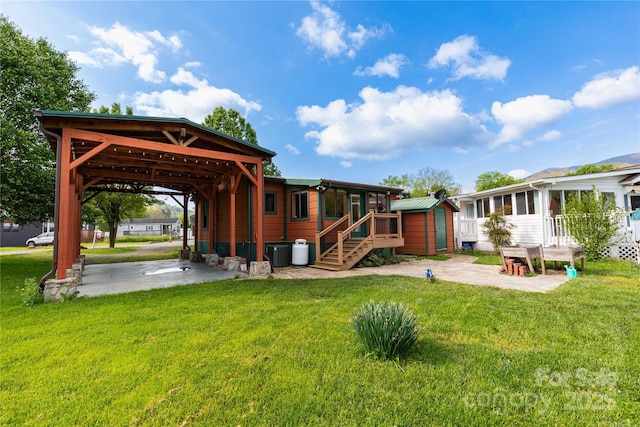214 Pike Pt, Waynesville, NC 28785 - rear view of house featuring a lawn, an outdoor structure, a sunroom, and central AC