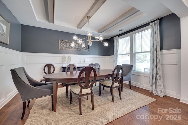 dining space with a decorative wall, a notable chandelier, and a wainscoted wall
