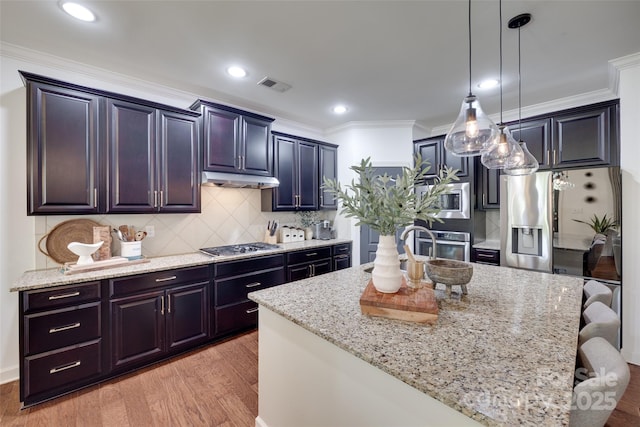 kitchen featuring stainless steel appliances, visible vents, light stone counters, and light wood-style floors