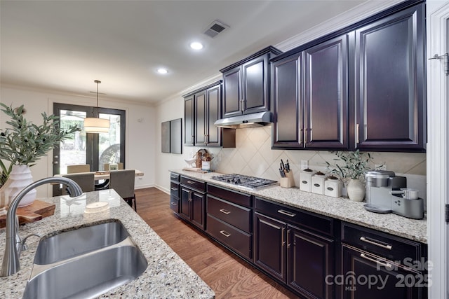 kitchen with visible vents, ornamental molding, stainless steel gas cooktop, under cabinet range hood, and a sink