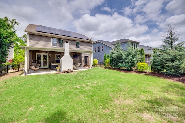 back of house with a lawn, solar panels, ceiling fan, and a patio area